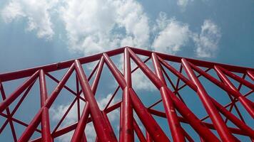 construction of the Indonesian railway bridge. a red structure with a blue sky and clouds photo