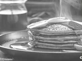 Stack of Buttery Pancakes Drenched in Syrup photo