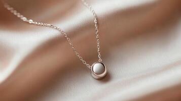 Minimalist Silver Necklace with Round Pendant on Soft Fabric photo