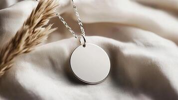 Simple Silver Round Pendant Necklace on White Fabric Background photo
