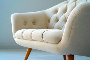 Chic modern sofa with button tufts and angular wooden legs isolated photo