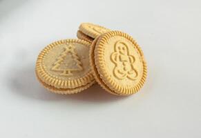 Round cookies with including Christmas symbols such as trees, snowmen and other holiday characters. Vanilla or butter sandwich cookies. photo