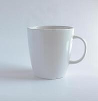 plain white ceramic mug with a simple handle. It has a clean and minimalistic design, perfect for enjoying coffee, tea, or any other hot beverage. photo