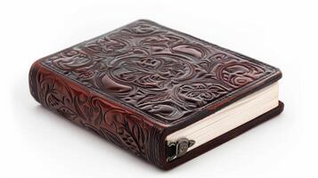 A beautifully crafted leather journal with intricate embossed designs resting on a clean surface, showcasing artisanal craftsmanship and fine details photo