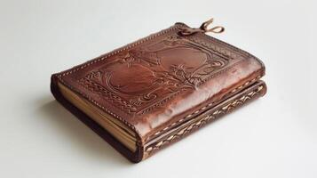 A handcrafted leather journal with intricate designs resting on a white surface photo