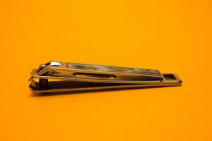 nail clipper isolated on yellow background photo