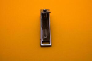 nail clipper isolated on yellow background photo
