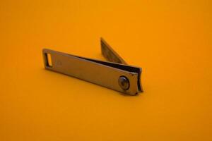 nail clipper isolated on yellow background photo