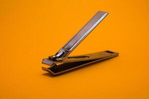 nail clipper isolated on yellow background photo