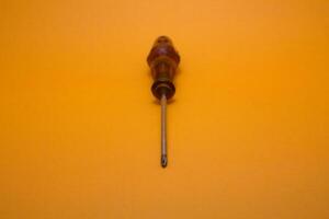 a red handle screwdriver isolated on yellow background photo
