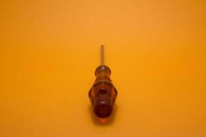a red handle screwdriver isolated on yellow background photo