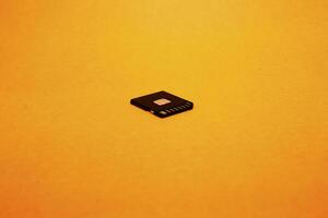 Black SD memory card isolated on yellow background photo
