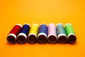 sewing thread roll isolated on yellow background photo