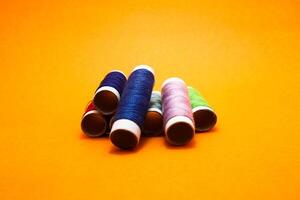 sewing thread roll isolated on yellow background photo