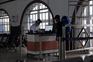A traveler and a train officer wearing a mask at the ticket check at Pasar Senen Station, Jakarta during the Covid-19 pandemic Jakarta, Indonesia - August 8, 2020 photo