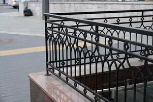 a black wrought railing on a street corner photo
