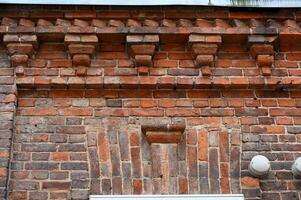 a brick wall with decorative brickwork and a clock photo