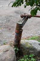 a rusty fire hydrant sitting on top of a rock photo