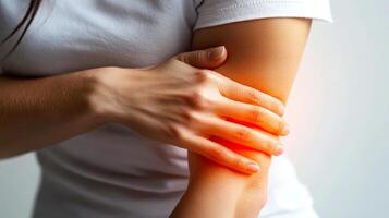 Woman Holding Elbow in Pain Close Up White Background photo