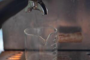 Prepare empty glass shot for espresso poured from coffee machine. photo