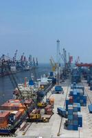 High angle view of commercial port with cranes and shipping containers, cranes move the shipping container to unload from cargo vessels photo