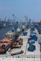 High angle view of business commercial port with cranes and logistics containers, cranes move the shipping container to unload logistics from cargo vessels photo