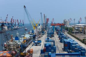Aerial scenery of port with cranes and shipping containers, cranes move the shipping container to unload from cargo ships photo