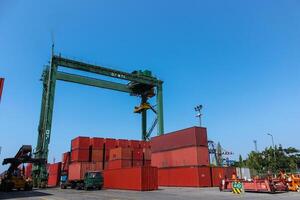 Loading and unloading shipping containers in an export import and commercial port with industrial crane and truck as transportation mode photo