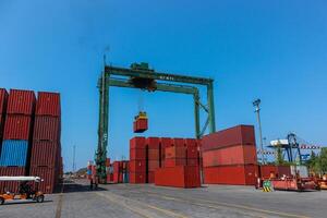 Industrial crane moving the shipping containers, activities in export import and commercial port in Jakarta, Indonesia photo