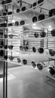 Monochrome photo of exclusive glasses displayed in a mall store.