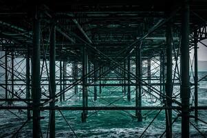 Structure of the pier base in Brighton, looks like scaffolding in blue water, East Sussex, UK photo