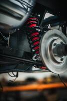 Classic, vintage, British car being restored on a ramp with visible front axle photo