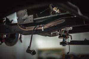 Classic, vintage, British car being restored on a ramp with visible chassis photo
