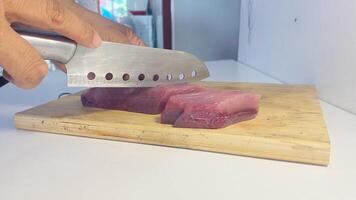 Slicing Raw Tuna Fish on a Cutting Board photo