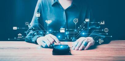 Businesswoman using computer mouse with icons on table photo
