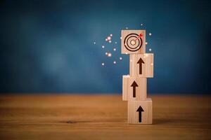 A wooden block with arrows and a target on top photo