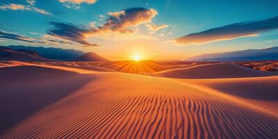 The sun setting behind towering dunes, casting long shadows across the desert photo