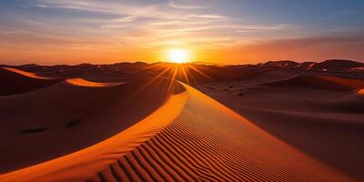 The sun setting behind towering dunes, casting long shadows across the desert photo