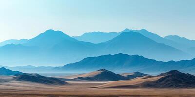 Distant mountains barely visible through desert haze, sand dunes in the foreground photo