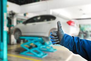 Thumb up for car repair work , The auto mechanic gives a thumb up to show confidence in a good job , Car maintenance service concept photo