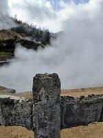damaged concrete fence due to exposure to sulfur vapor coming out of the Sikidang geothermal crater in Wonosobo, Indonesia photo