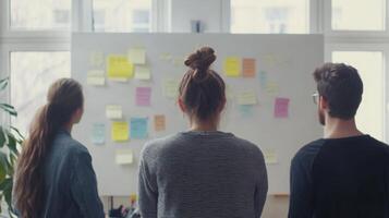 Coworkers brainstorming in front of a whiteboard, full of energy and new ideas photo