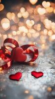 Intertwined red hearts made from ribbon resting on a silver sparkling floor with golden heart-shaped bokeh and fairy lights, dreamy and romantic tones photo