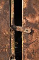 a rusty door with a padlock on it photo