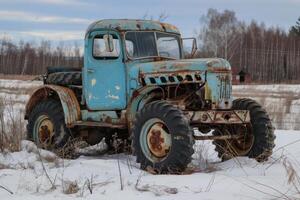 Old rusty truck slowly decomposing in snowy field photo