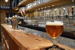 Glass of amber beer standing on counter in busy bar photo