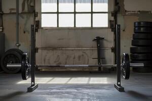 Barbell sitting on rack inside of a gym with weights in background photo