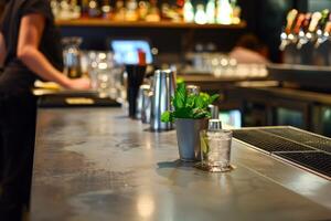 Fresh mint julep cocktail sitting on bar with bartender working in background photo