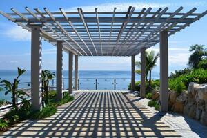 Beautiful pergola is casting shadows on the ground on a sunny day photo