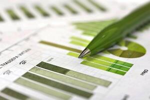 Green pen pointing at data on business graph chart photo